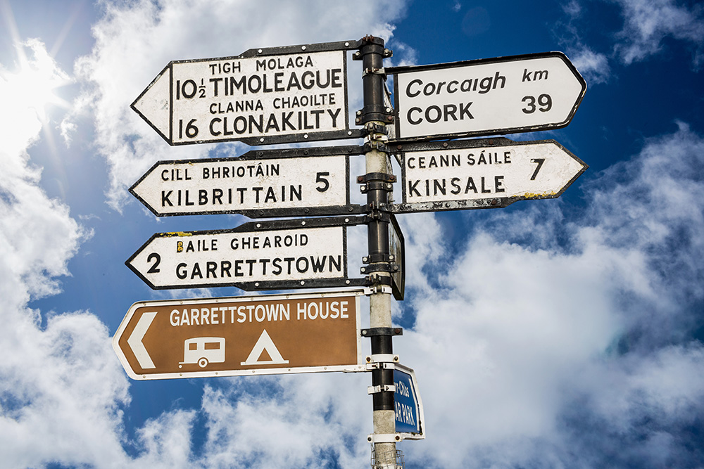 Sign post pointing towards Clonakilty against a sky backdrop.