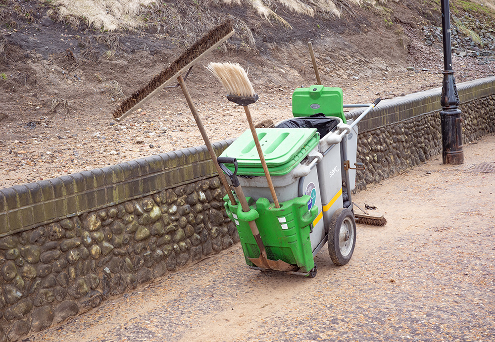 Tidy Towns branded portable litter bin on a spotless pavement.