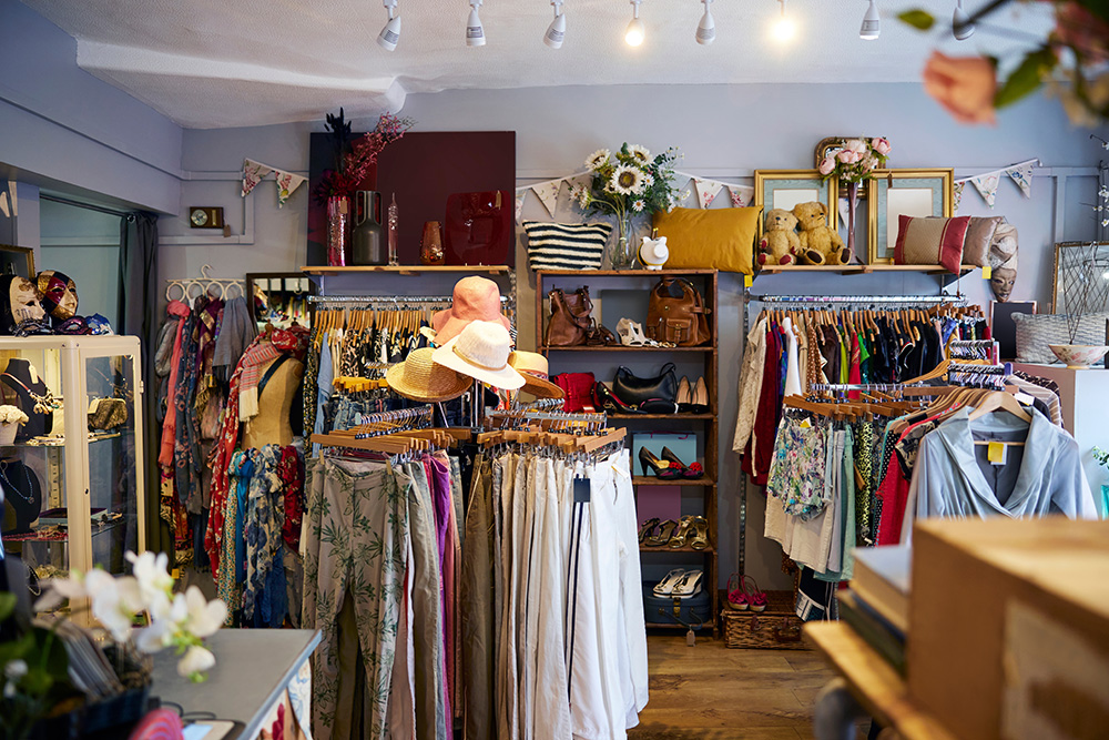 Interior view of a bustling charity shop in Ireland, showcasing sustainable clothing and household items.