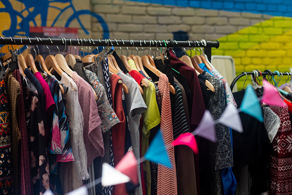 Colorful secondhand clothes displayed on hangers at a street market in Ireland, 2023.